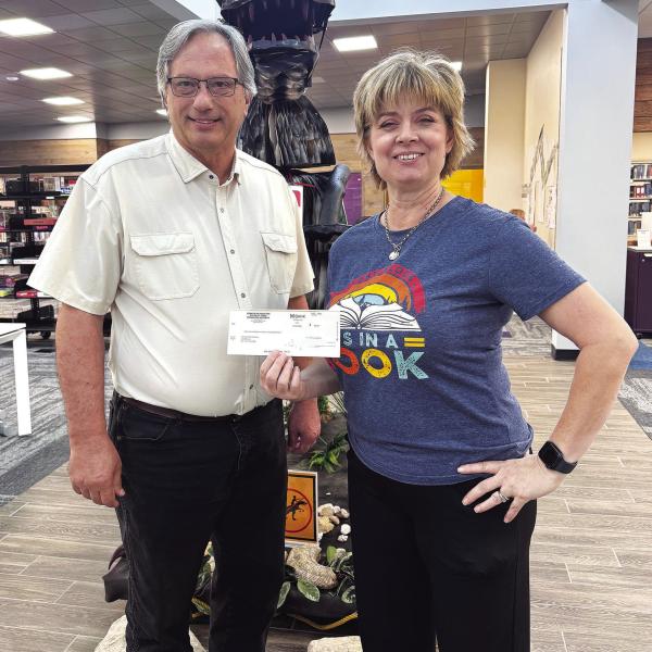 Hamilton County Judge James Yates presented Hamilton Public Library Director Kym Jeschke with a donation to support literacy programs at the local library.