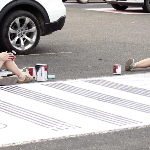 Keeping with tradition, senior Catherine Hooper was spotted Saturday morning painting her reserved parking spot in anticipation of the upcoming school year with assistance from her mother Nina. Each year, incoming Hamilton High School seniors are allowed to not only reserve a parking space, but to also utilize their spot as a palette for creativity. Photo by Grant Lengefeld
