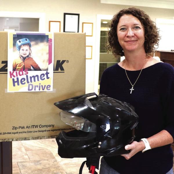 MCBank Vice President and Senior Loan Officer Mandy Blackwell is holding a helmet donated to a program Mayor Todd Jordan arranged with local banks. Citizens have an opportunity to donate money or helmets to the city, which they will in turn provide to families who do not have the resources to purchase a helmet. Donations can be dropped off at Extraco Bank, MCBank and Huntington Bank. Photo by Kate Edwards