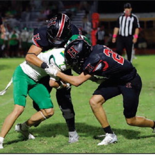 RED AND BLACK DEFENSE: Kyler Kother assists on the tackle of the Dublin Lion. The Hamilton defense held Dublin to just 152 total offensive yards. Photos by Tracy Cox