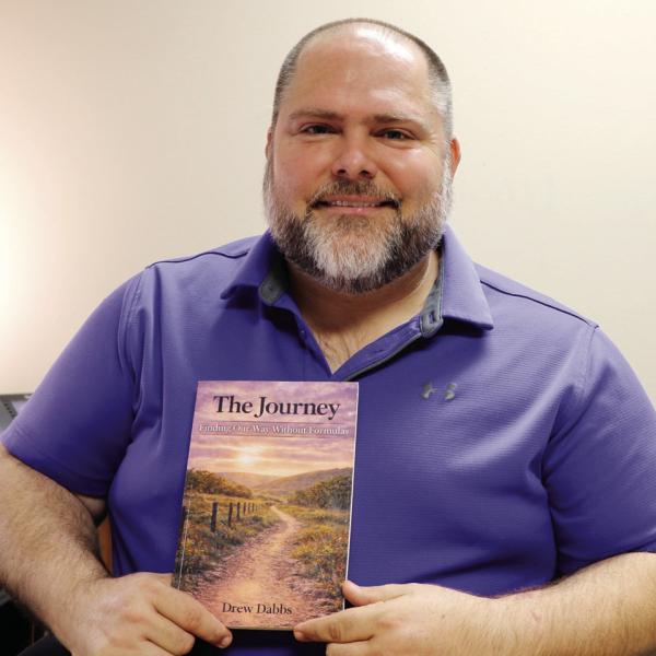 DREW’S JOURNEY: Drew Dabbs, pastor of First Baptist Church, holds the book he authored, The Journey: Finding Our Way Without Formulas. Photo by Maria Weaver