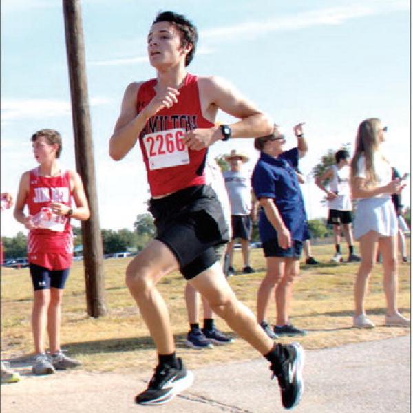 Sophomore Elijah Looke caught mid-stride with a little lift off the concrete in Stephenville City Park. Looke placed 47th with a time of 19:44.53. Photo by Jennifer Bolton