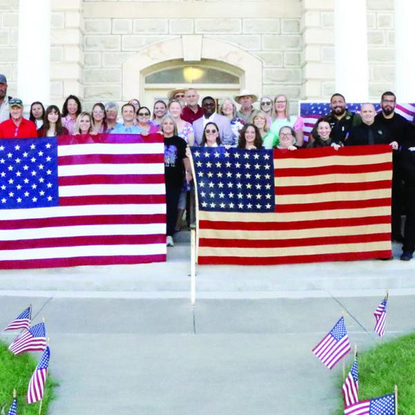 STARS OF HISTORY: County and city workers and local police gathered on the Hamilton County Courthouse lawn with two American flags in honor of the upcoming celebration of America’s 250 years of independence. The flag on the left side has 50 stars, while the flag on the right has 48 stars. Photo by Jaxon Hansard