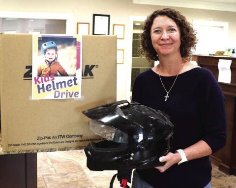 MCBank Vice President and Senior Loan Officer Mandy Blackwell is holding a helmet donated to a program Mayor Todd Jordan arranged with local banks. Citizens have an opportunity to donate money or helmets to the city, which they will in turn provide to families who do not have the resources to purchase a helmet. Donations can be dropped off at Extraco Bank, MCBank and Huntington Bank. Photo by Kate Edwards