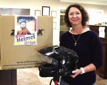 MCBank Vice President and Senior Loan Officer Mandy Blackwell is holding a helmet donated to a program Mayor Todd Jordan arranged with local banks. Citizens have an opportunity to donate money or helmets to the city, which they will in turn provide to families who do not have the resources to purchase a helmet. Donations can be dropped off at Extraco Bank, MCBank and Huntington Bank. Photo by Kate Edwards