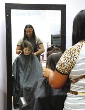 BACK-TO-SCHOOL CUTS: For the tenth consecutive year, free back-to-school haircuts for students are being offered Saturday, Aug. 8, from 8 a.m. to noon at Rejuvenation Station, located at 120 E. Main Street in Hamilton. School supply donations will also be accepted during the event. Organizer Andrea Fletcher is pictured last year administering a back-to-school cut. Photo by Grant Lengefeld