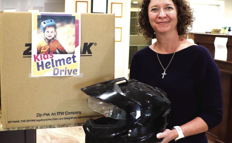 MCBank Vice President and Senior Loan Officer Mandy Blackwell is holding a helmet donated to a program Mayor Todd Jordan arranged with local banks. Citizens have an opportunity to donate money or helmets to the city, which they will in turn provide to families who do not have the resources to purchase a helmet. Donations can be dropped off at Extraco Bank, MCBank and Huntington Bank. Photo by Kate Edwards