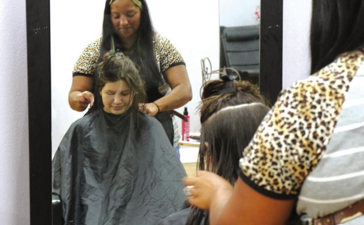 BACK-TO-SCHOOL CUTS: For the tenth consecutive year, free back-to-school haircuts for students are being offered Saturday, Aug. 8, from 8 a.m. to noon at Rejuvenation Station, located at 120 E. Main Street in Hamilton. School supply donations will also be accepted during the event. Organizer Andrea Fletcher is pictured last year administering a back-to-school cut. Photo by Grant Lengefeld
