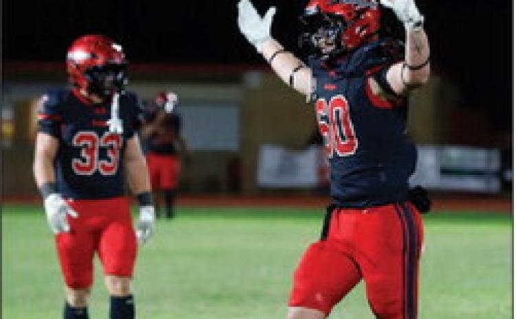 DEFENSIVE STANDOUT: Senior Vanden Phillips (No. 60) celebrates after the Bulldogs’ defense forces a turnover on downs against the Cubs Friday night. Phillips ended the match with four tackles, two tackles for loss, one sack and five quarterback pressures in the 42-7 win. Photo by Tracy Cox