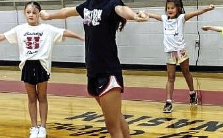 SPIRIT IS IN THE AIR - HHS Cheerleaders have started their season. While seniors worked with the new cheerleaders, Miss Leach had the others, including (l-r) Aubrey Ensor, Harper Lengefeld, Emery McElroy and Marley Boatwright, working on spirit signs and paw prints. At right, Cydney Dolloff works with campers at Little Cheer Camp Monday. Camp concluded Wednesday as Football Camp began for incoming 1st through 9th grade boys at the practice field. Courtesy Photos